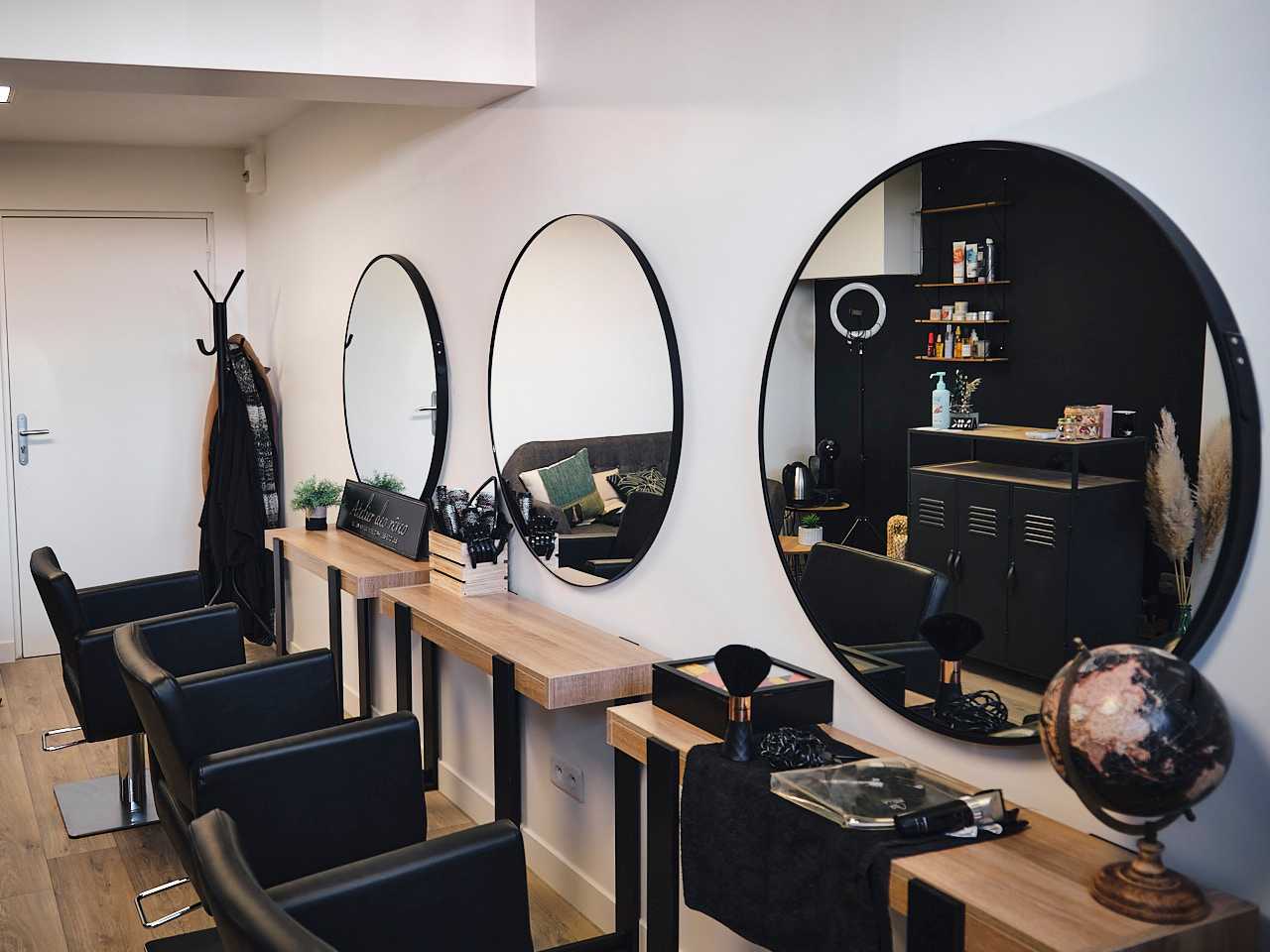 Le salon de coiffure de MK Hairstylist, les trois sièges de coiffure avec en face des miroirs ronds.